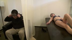 A married woman gets a massage while her husband is next to her. 2